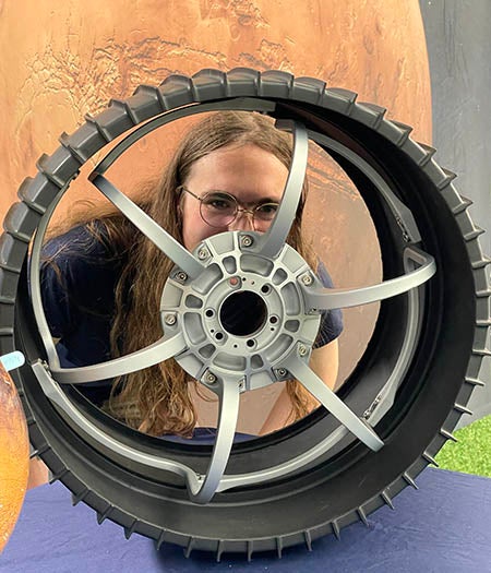 Graduate Student Audrey Putnam with Mars rover wheel