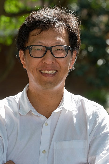 Photo of head and shoulders of smiling man outdoors