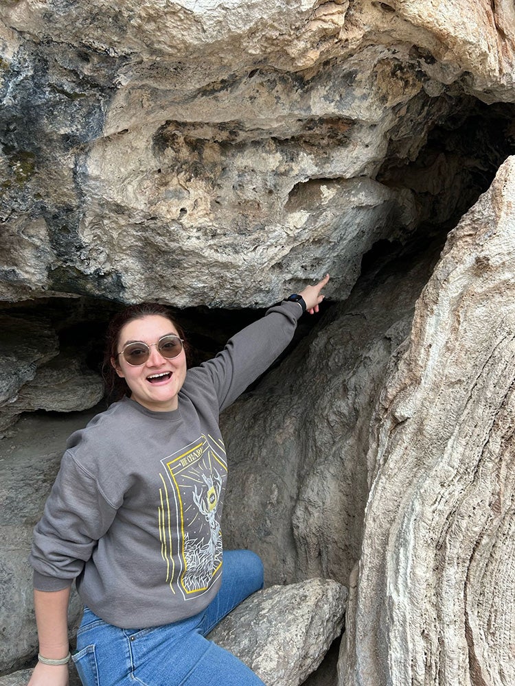 Image of young woman in front of rock outcrop