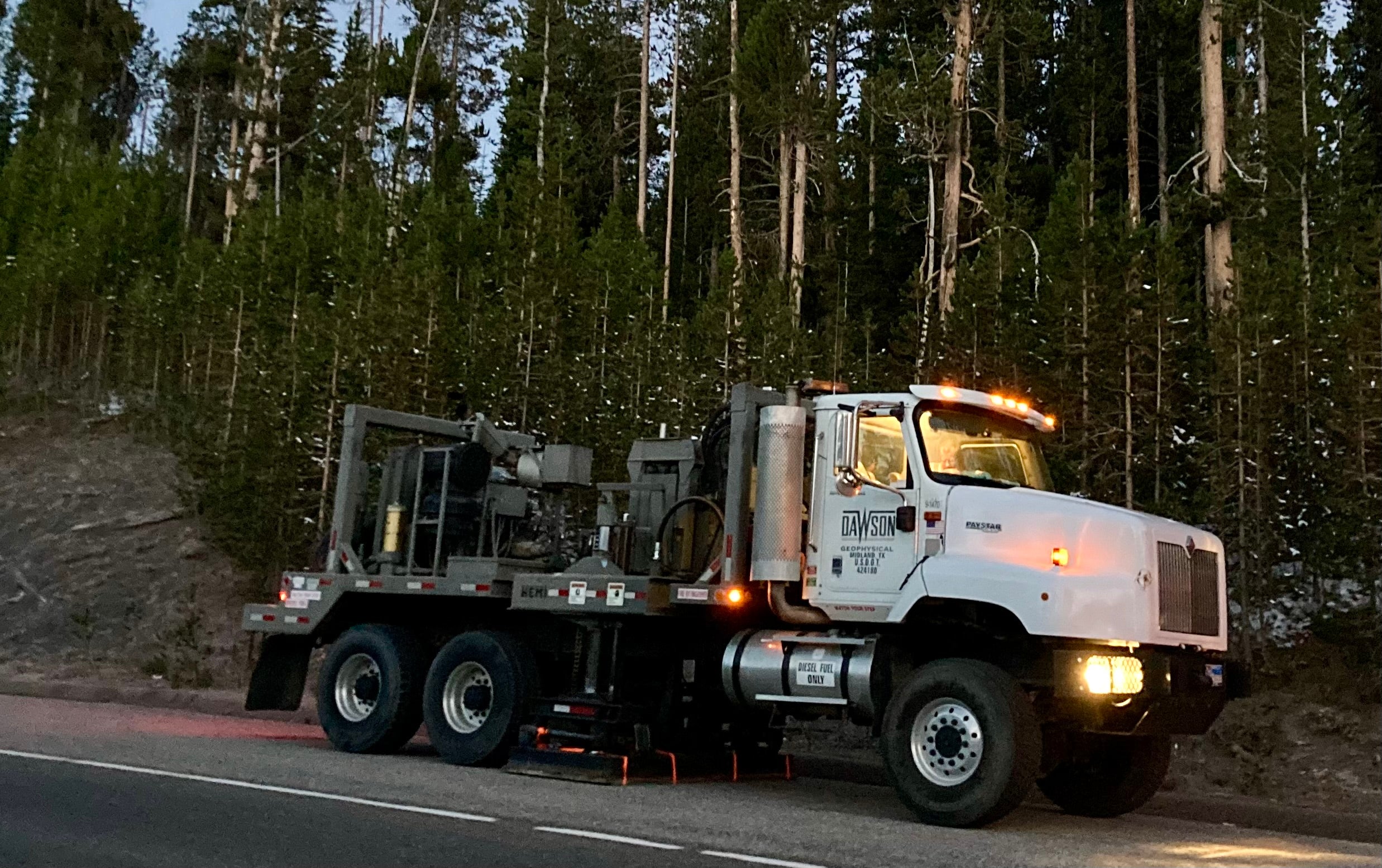 Image of a Dawson Geophysical 'Vibe Truck' parked along a forested roadway (permit YELL-2020-SCI-8146)
