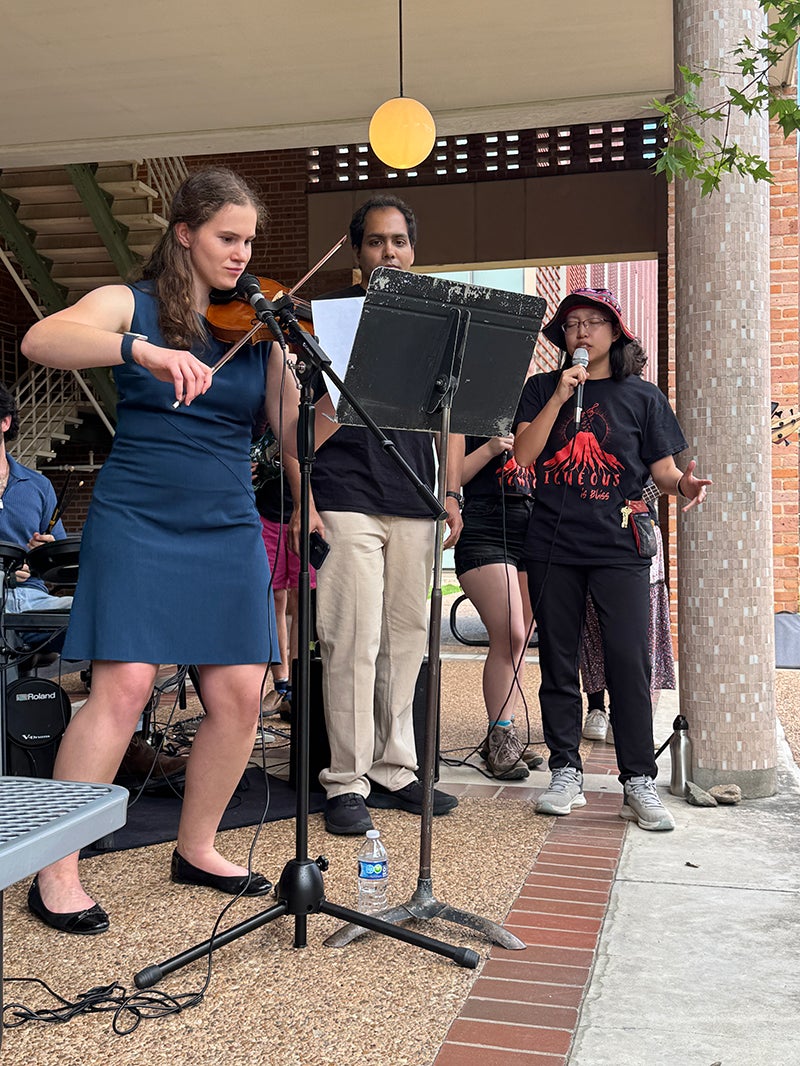 Photo of Nyla Hartigan playing violin in the undergraduate band 'Igneous is Bliss'