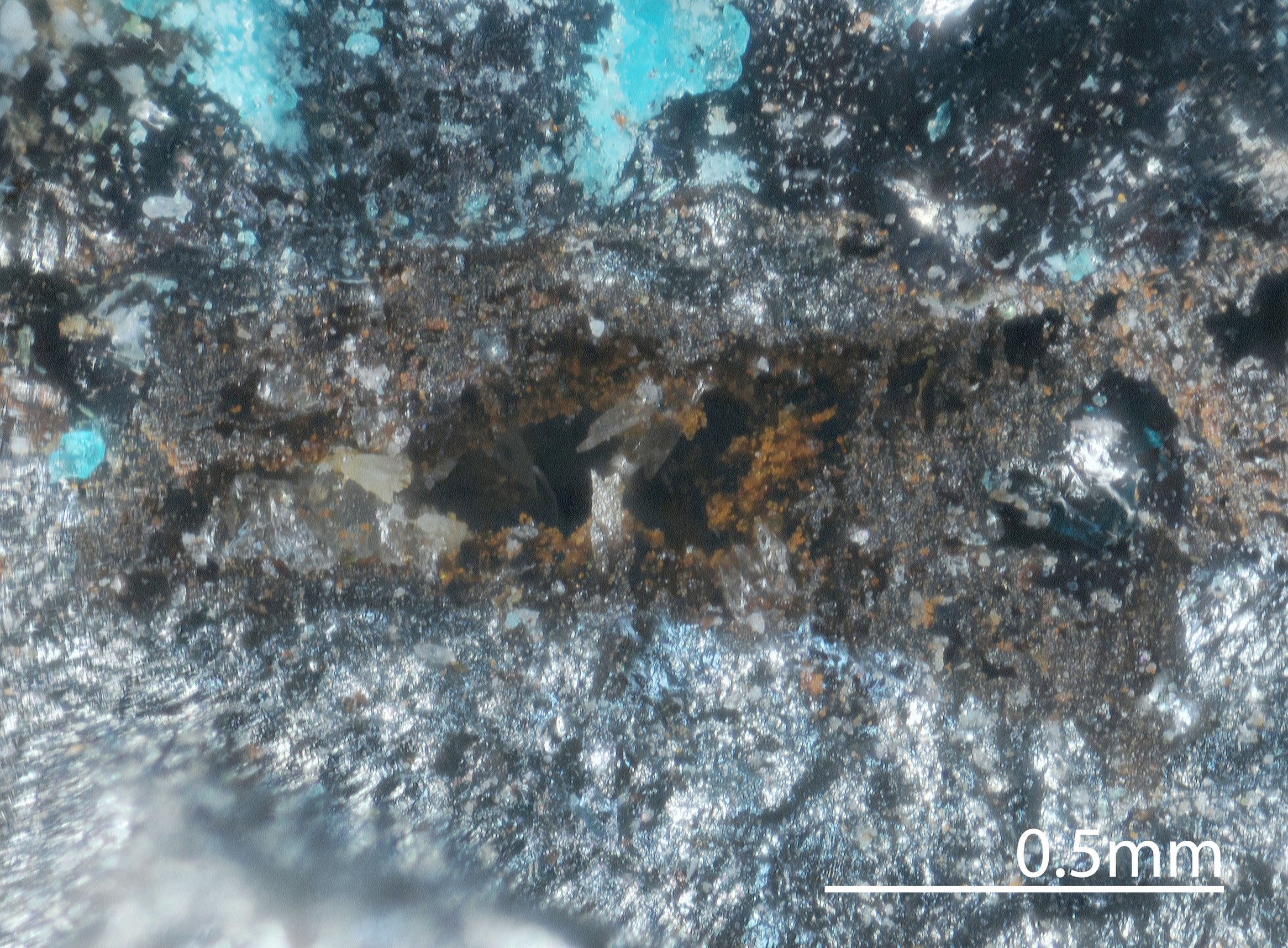 Molybdomenite (narrow yellowish crystals) found inside a vug. 