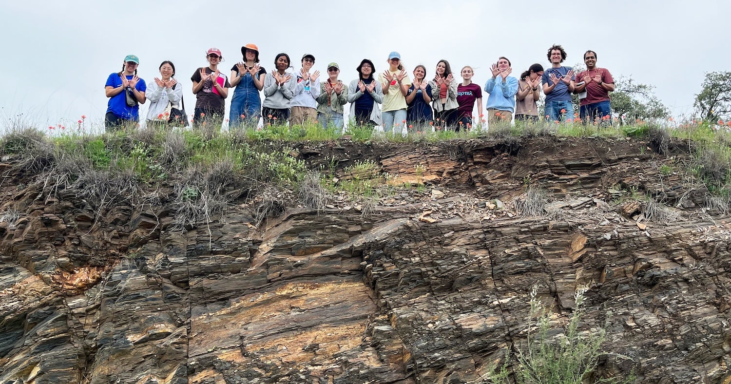 Undergraduate students overlooking rock outcrop