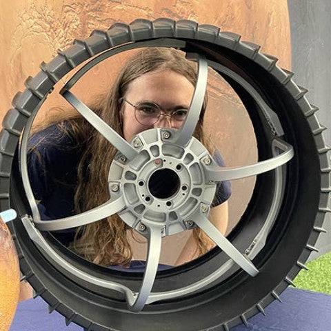 Graduate Student Audrey Putnam with Mars rover wheel