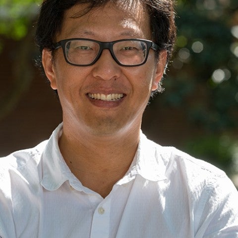 Photo of head and shoulders of smiling man outdoors